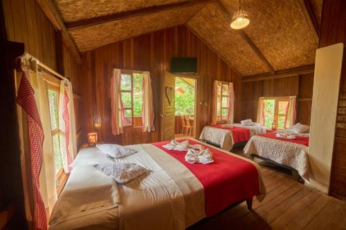 a bedroom with two beds in a room at Carolina Egg Gasthaus in Oxapampa