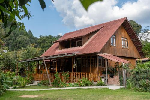 a wooden house with a red roof at Carolina Egg Gasthaus in Oxapampa