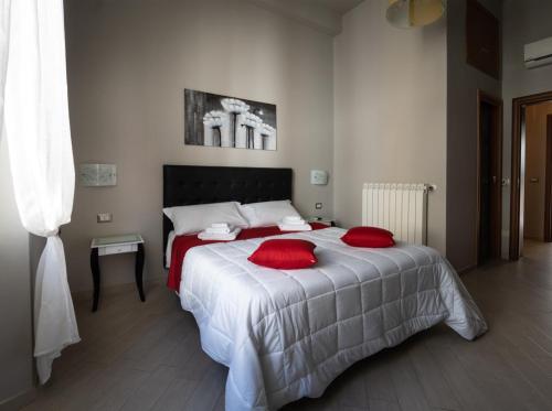 a bedroom with a bed with red pillows on it at CONTE CAVOUR in Messina