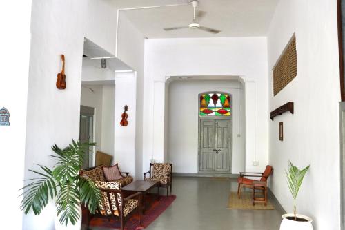a hallway with chairs and a door with a stained glass window at Balcony House in Zanzibar City