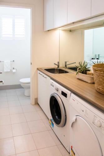 a laundry room with a washer and a sink at Luxury Norwood Retreat in Norwood