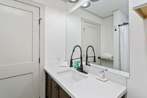 Baño blanco con lavabo y espejo en Blue View Chalet en Blowing Rock