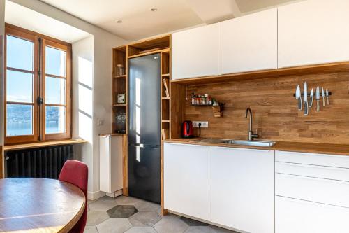a kitchen with a table and a refrigerator at Le DUPLEX DU LAC in Veyrier-du-Lac
