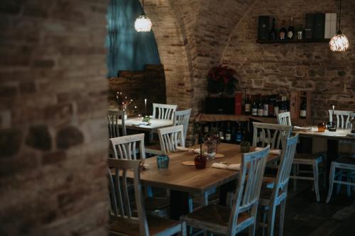 a dining room with tables and chairs and a brick wall at La Maison Rosa Stella in Lucera