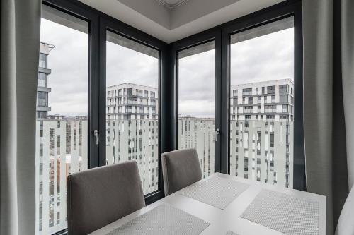 a table and chairs in a room with windows at Garden Towers in Prague
