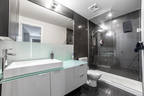 a bathroom with a sink and a toilet and a shower at Luxury Condo w/Mesmerizing Sunset Views & FREE Parking in Toronto