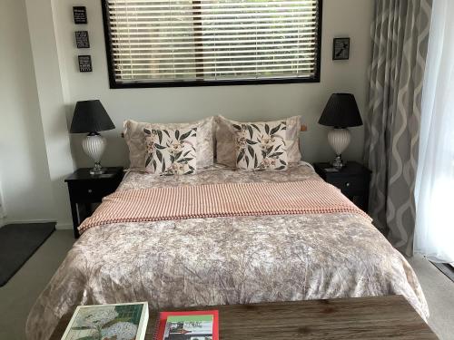 a bedroom with a large bed with two night stands at Botanical Haven BnB in Tauranga