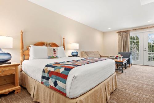 a large bedroom with a large bed and a chair at Sag Harbor Inn in Sag Harbor