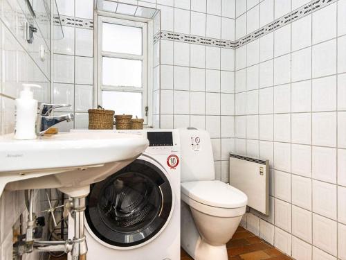 La salle de bains est pourvue d'un lave-linge et d'un lavabo. dans l'établissement Holiday home Rømø CXXI, à Kongsmark
