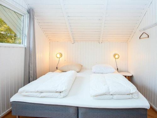 2 Betten in einem kleinen Zimmer mit Fenster in der Unterkunft Holiday home Fårvang VII in Fårvang