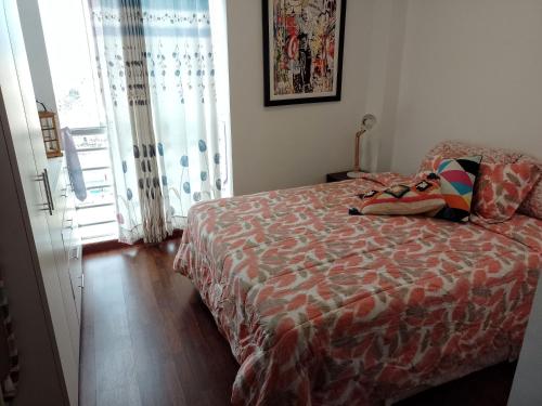 a bedroom with a bed with a colorful comforter at Agradable, en el centro y con cochera in Trujillo
