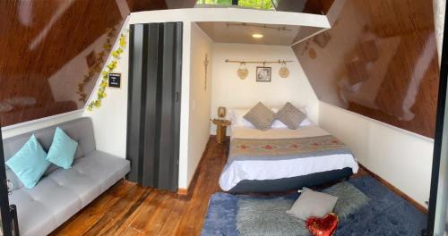 1 dormitorio pequeño con 1 cama y 1 sofá en Glamping El Pinar, en San Francisco
