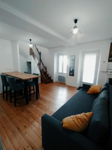 uma sala de estar com um sofá azul e uma mesa em C'COZY - grande maison calme et lumineuse em Sablé-sur-Sarthe