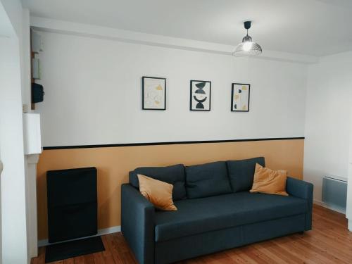 Sofá azul en una sala de estar con pared en C'COZY - grande maison calme et lumineuse, en Sablé-sur-Sarthe