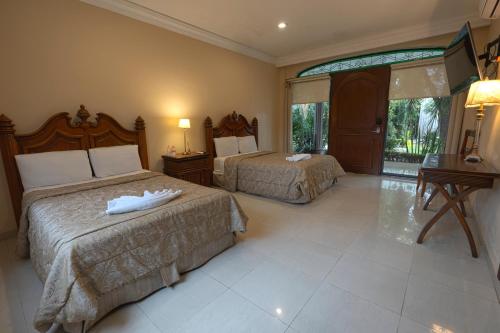 a hotel room with two beds and a window at Gran Hotel Firenze in Tequisquiapan