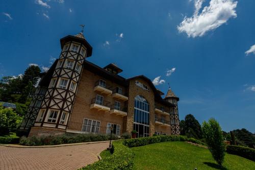 a building with a clock tower on the side of it at Carballo Hotel & Spa in Campos do Jordão