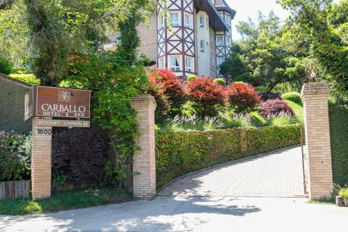 a sign for a garden in front of a house at Carballo Hotel & Spa in Campos do Jordão