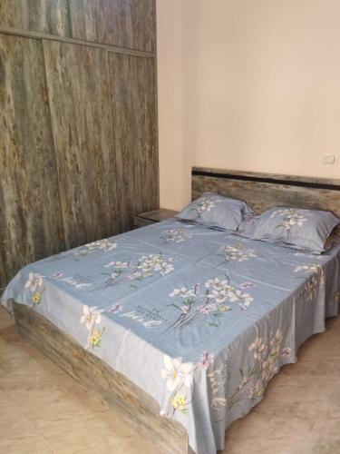a bed with a blue comforter with flowers on it at Hurghada City Apartment2 in Hurghada