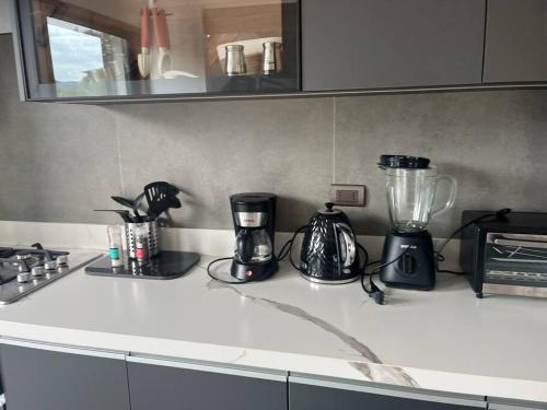 a kitchen counter with appliances on a counter top at Casa nueva en country pucon con piscina y quincho compartido con casa gemela in Pucón