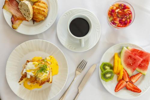 una mesa blanca con platos de comida y una taza de café en Carballo Hotel & Spa, en Campos do Jordão