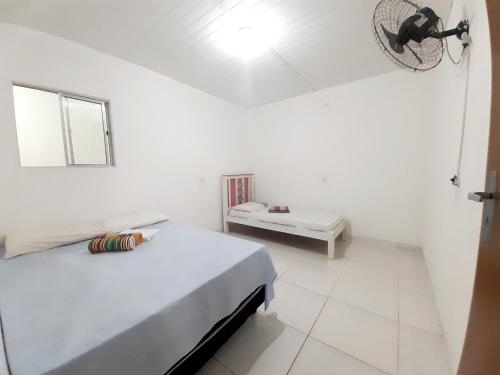 Habitación blanca con cama y mesa en Pousada Aconchego Sol e Mar, en Maragogi