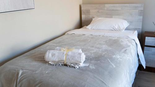 a bed with two towels and a pillow on it at Hotel La Casona del Desierto in Huasco