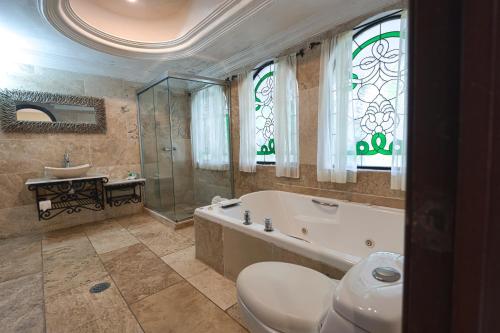 uma casa de banho com uma banheira, um WC e um lavatório. em Gran Hotel Firenze em Tequisquiapan
