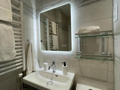 een witte badkamer met een wastafel en een spiegel bij Moment magique aux pieds des pistes à Superdevoluy in Le Dévoluy