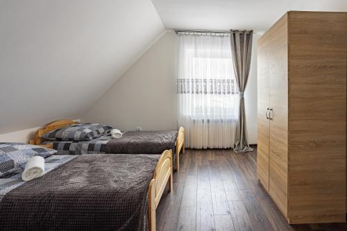 a bedroom with three beds and a window at Apartament w Lasku in Nowy Targ