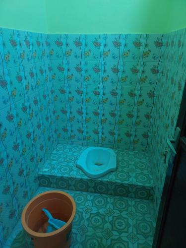 uma casa de banho com um WC azul num quarto em kost maqmil em Prambanan