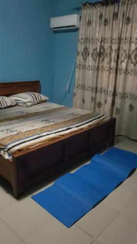 Bett in einem Zimmer mit blauer Wand in der Unterkunft Dave's abode in Benin City