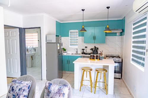 a kitchen with blue cabinets and two bar stools at Homes of Ace Gold in Pretoria