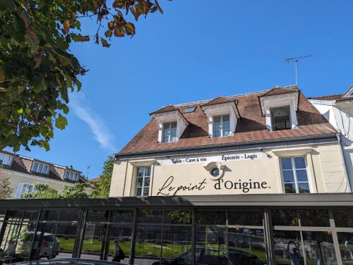 um edifício com um sinal para um restaurante em Le Logis d'Origine. em Marly-le-Roi