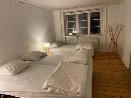 two twin beds in a room with a window at Indre by in Copenhagen