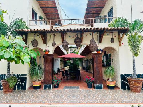 a building with a patio with an umbrella and a table at Bungalows Las Glorias in Rincon de Guayabitos