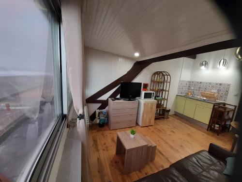 een woonkamer met een groot raam en een televisie bij L'Anéda - STUDIO vue panoramique sur Mer - 2 personnes - Animaux OK - Wifi in Mers-les-Bains