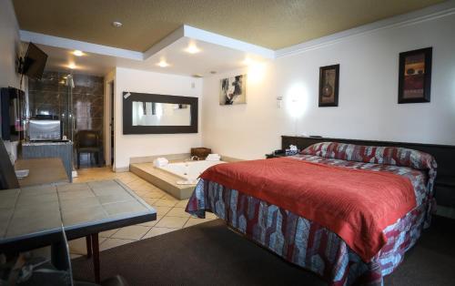 um quarto de hotel com uma cama e uma banheira em Motel Classique em Joliette