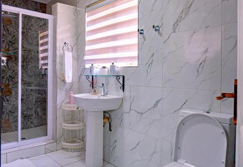 a white bathroom with a sink and a shower at Homes of Ace Gold in Pretoria