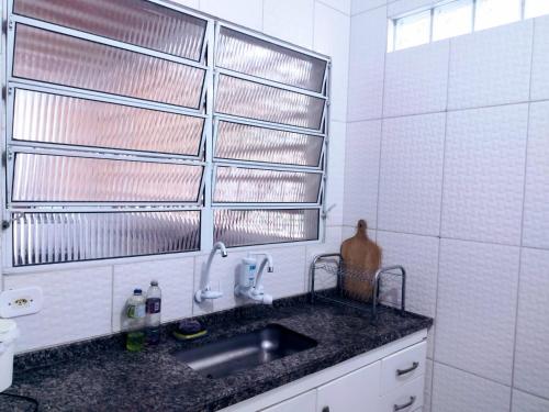 une cuisine avec un évier et une fenêtre au-dessus dans l'établissement Casa na praia para até 10 pessoas, à São Sebastião