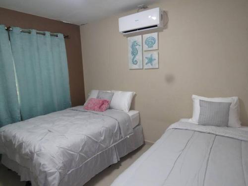 sypialnia z dwoma łóżkami i telewizorem w obiekcie Casa en Ceiba 15 min de la playa w mieście La Ceiba