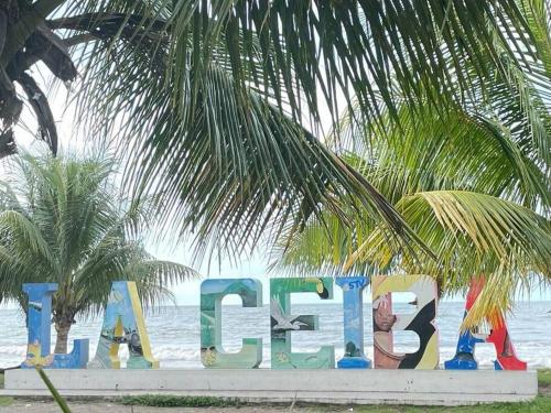 a sign for a beach with a palm tree at Casa en Ceiba 15 min de la playa in La Ceiba