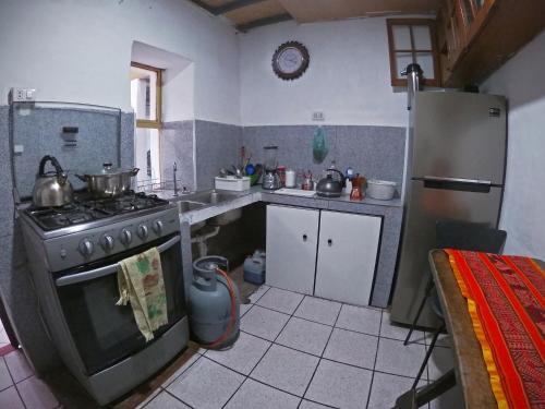 Il comprend une cuisine équipée d'une cuisinière et d'un réfrigérateur. dans l'établissement MORENAS BACKPACKERs, à Cusco