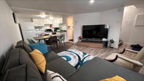 a living room with a couch and a kitchen at Le Cent Onze in Gatineau