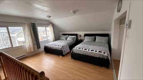 a bedroom with two beds and a window at Le Cent Onze in Gatineau