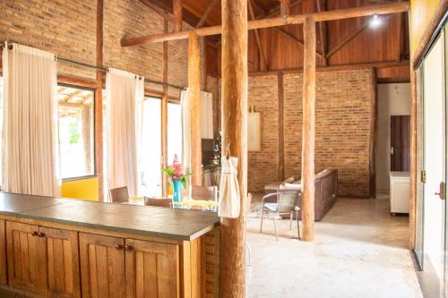 a kitchen and living room with a brick wall at Casa das Pedras in Lagoa Santa