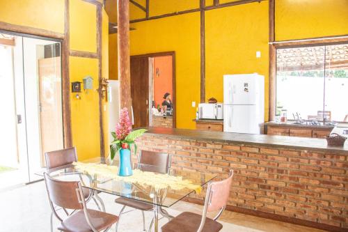 a table and chairs in a kitchen with yellow walls at Casa das Pedras in Lagoa Santa