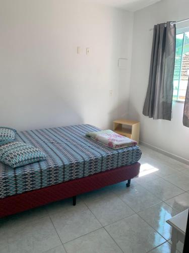 1 dormitorio con 1 cama en una habitación con ventana en Recanto dos Ganchos, en Governador Celso Ramos