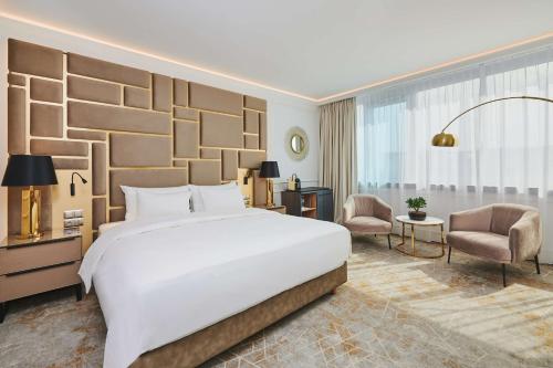 シュチェチンにあるラディソンブルー シュチェチンの大きなベッドと椅子が備わるホテルルームです。