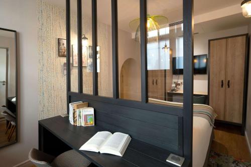 a bedroom with a mirror and a bed with books at Hotel Litteraire Marcel Ayme, BW Premier Collection in Paris