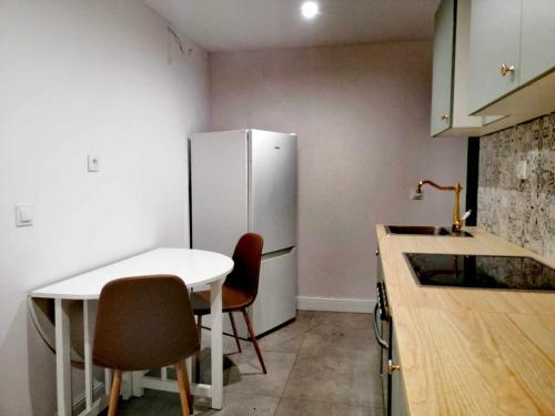 een keuken met een witte tafel en een koelkast bij Apartament.Ul.Krótka in Toruń